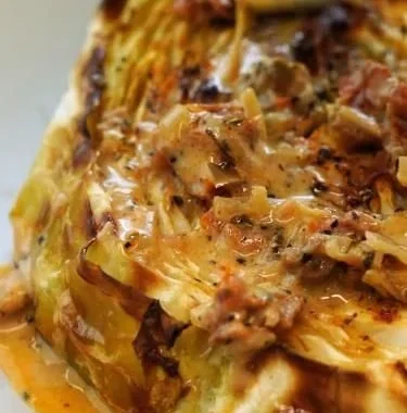 Cabbage steaks with sun-dried tomato cream sauce served on a plate