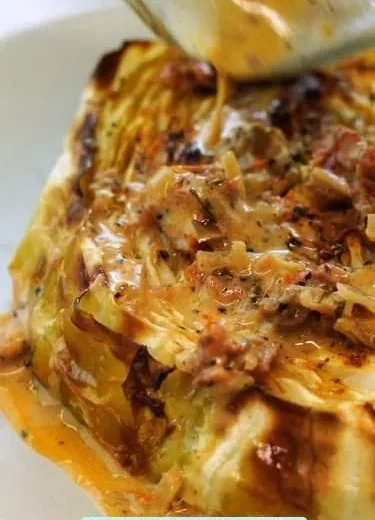 Cabbage steaks with sun-dried tomato cream sauce served on a plate
