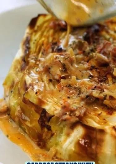 Cabbage steaks with sun-dried tomato cream sauce served on a plate