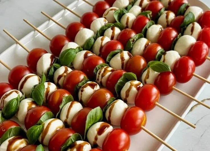Colorful Caprese Skewers with mozzarella, tomatoes, and basil on a platter