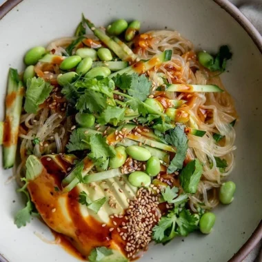 Bowl of cold sesame miso noodles topped with sesame seeds and green onions