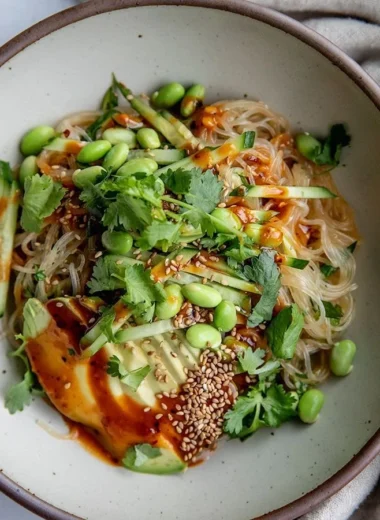 Bowl of cold sesame miso noodles topped with sesame seeds and green onions