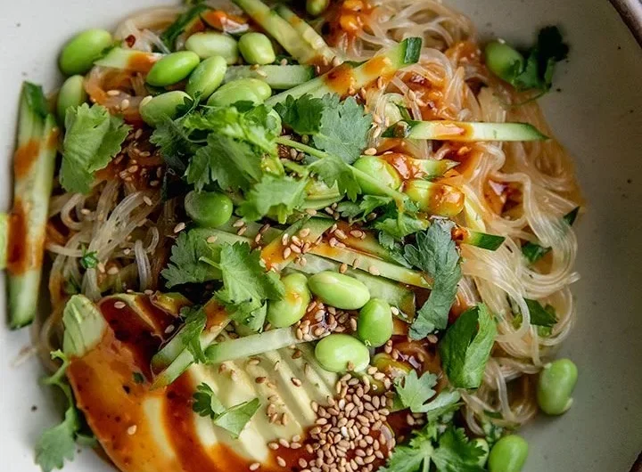 Bowl of cold sesame miso noodles topped with sesame seeds and green onions