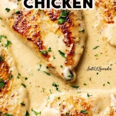 Creamy garlic parmesan chicken served on a plate with garnishes.