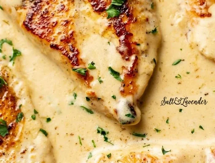 Creamy garlic parmesan chicken served on a plate with garnishes.