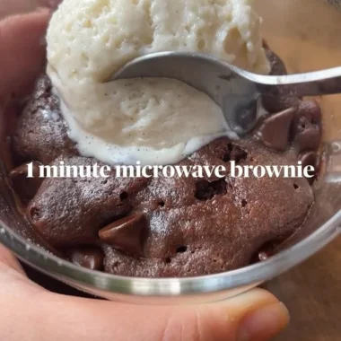 Fudgy brownie mug cake in a white mug topped with chocolate chips