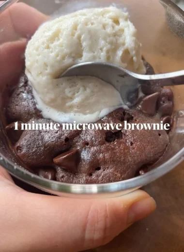 Fudgy brownie mug cake in a white mug topped with chocolate chips