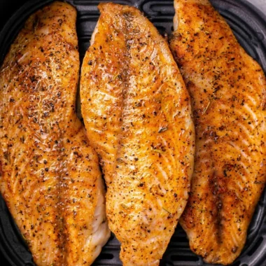 Delicious Air Fryer Tilapia garnished with herbs and lemon slices