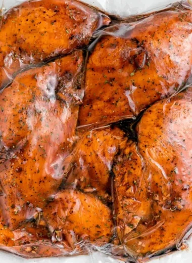 Marinated balsamic chicken ready for grilling with fresh herbs