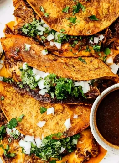 Delicious Beef Birria Tacos topped with gooey cheese and fresh herbs