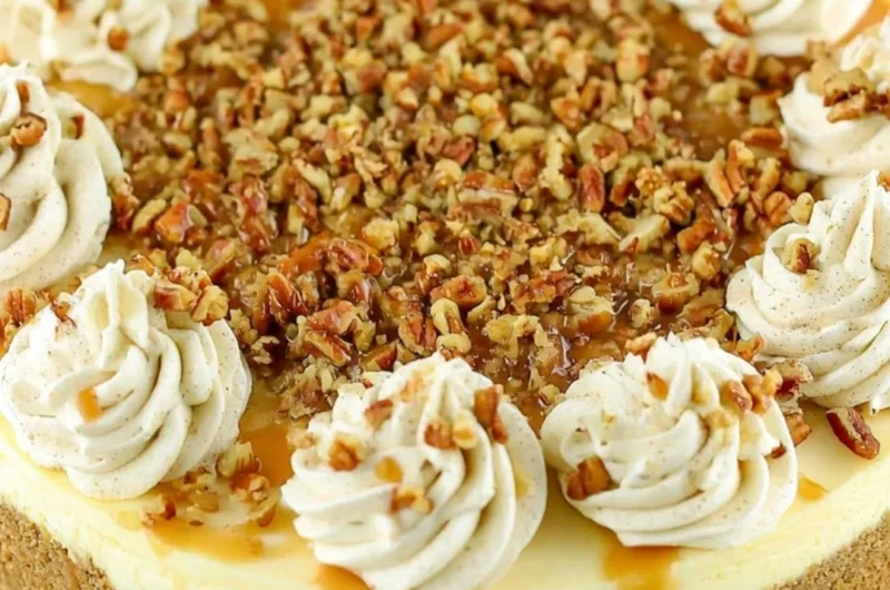 Slice of browned butter pecan cheesecake on a plate with pecans on top