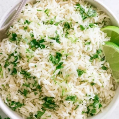 Bowl of cilantro lime rice with fresh cilantro and lime slices