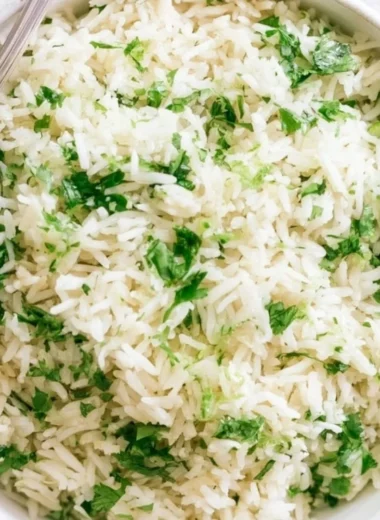 Bowl of cilantro lime rice with fresh cilantro and lime slices