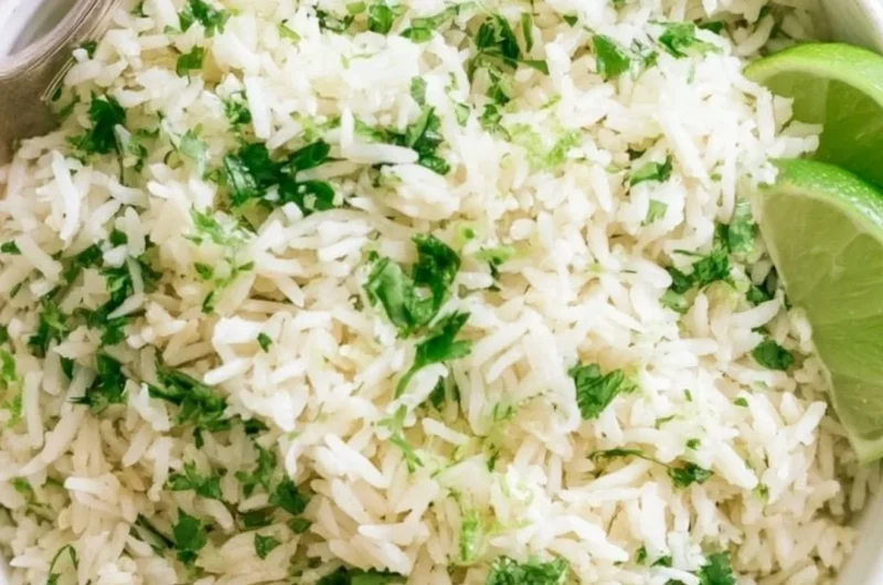 Bowl of cilantro lime rice with fresh cilantro and lime slices