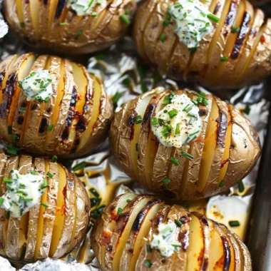 Cozy Hasselback Potatoes topped with chive butter in a rustic setting.