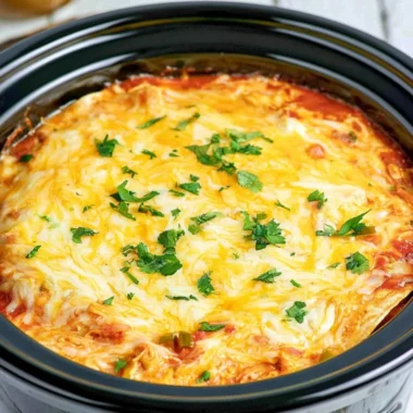 Crockpot Chicken Enchilada Casserole topped with cheese and fresh ingredients