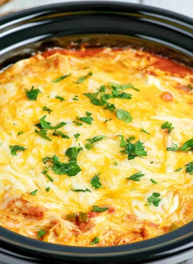 Crockpot Chicken Enchilada Casserole topped with cheese and fresh ingredients