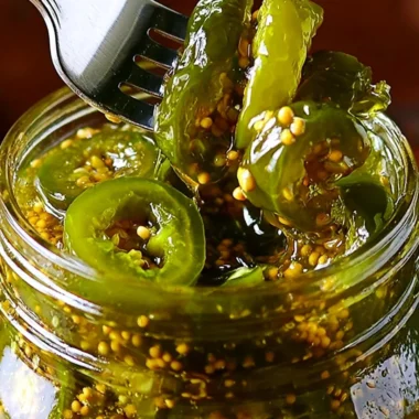 Jar of homemade cowboy candy with jalapeños and syrup