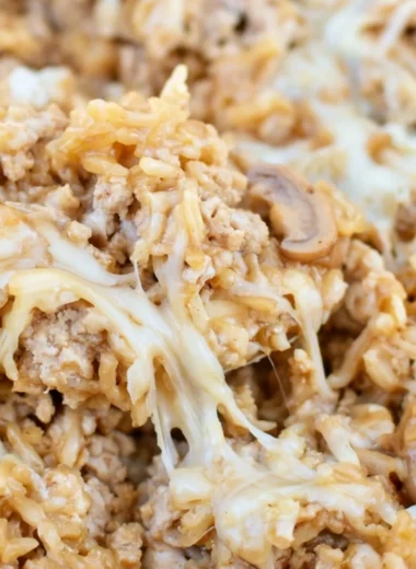Ground turkey skillet casserole topped with cheese and vegetables.