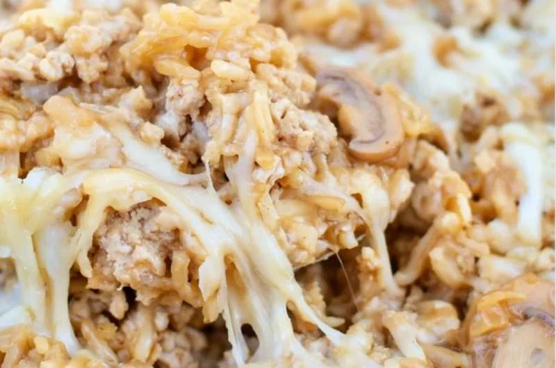 Ground turkey skillet casserole topped with cheese and vegetables.