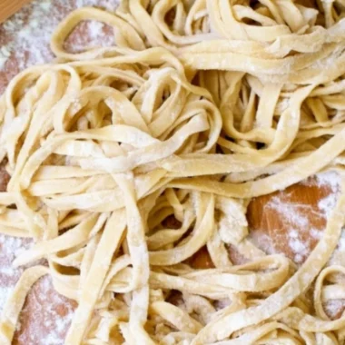 Plate of homemade egg noodles topped with sauce and herbs