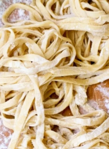 Plate of homemade egg noodles topped with sauce and herbs