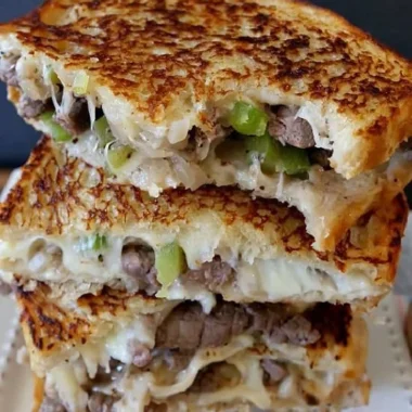 Mouthwatering Philly Cheesesteak Grilled Cheese sandwich loaded with gooey cheese.