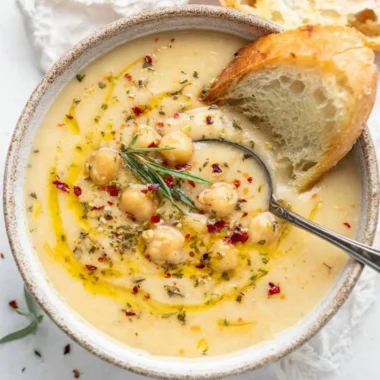 Bowl of Vegan Garlic Chickpea Soup garnished with herbs and spices