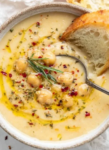 Bowl of Vegan Garlic Chickpea Soup garnished with herbs and spices
