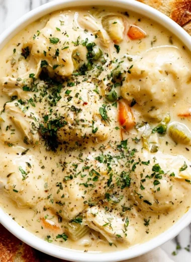 Bowl of cozy chicken dumpling soup with fluffy dumplings and vegetables