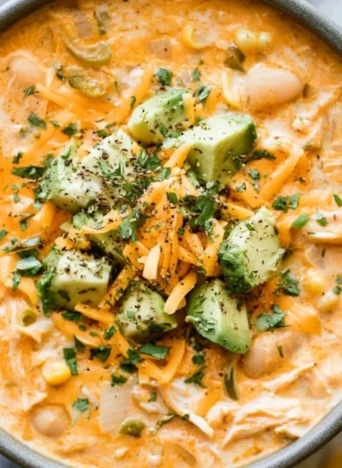 Bowl of cozy creamy white chicken chili topped with cilantro and tortilla strips.