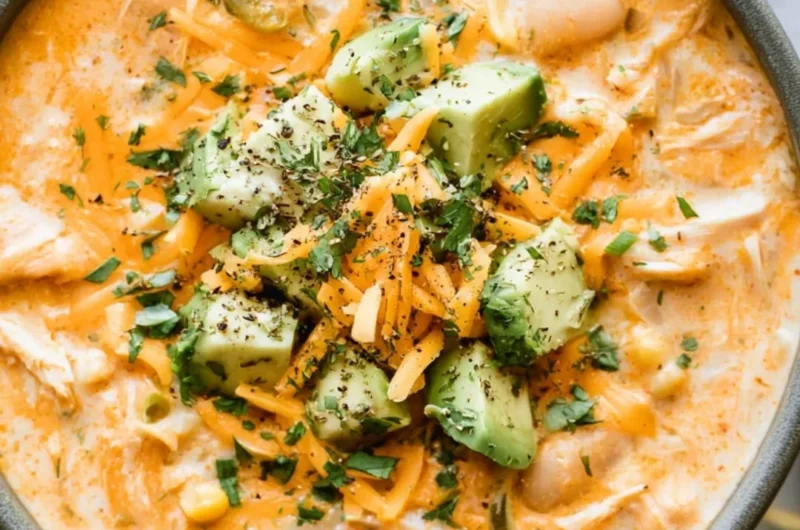 Bowl of cozy creamy white chicken chili topped with cilantro and tortilla strips.