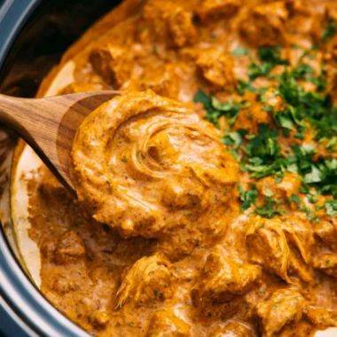Cozy Crockpot Butter Chicken served with rice and garnished with cilantro.