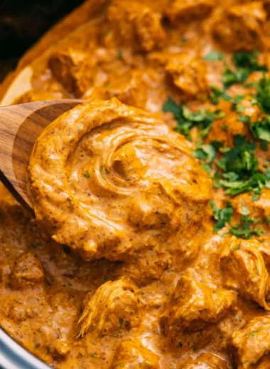 Cozy Crockpot Butter Chicken served with rice and garnished with cilantro.