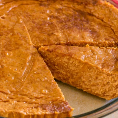 Cozy crustless pumpkin pie served in a white dish with whipped cream on top