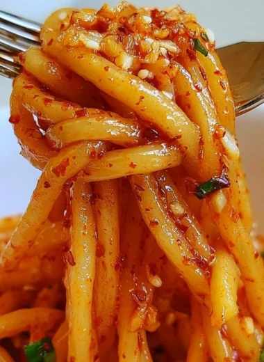 Delicious garlic chili oil noodles served in a bowl, garnished with herbs.