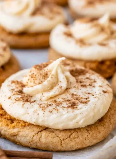 Cozy pumpkin cookies with cream cheese frosting on a autumn-themed plate.