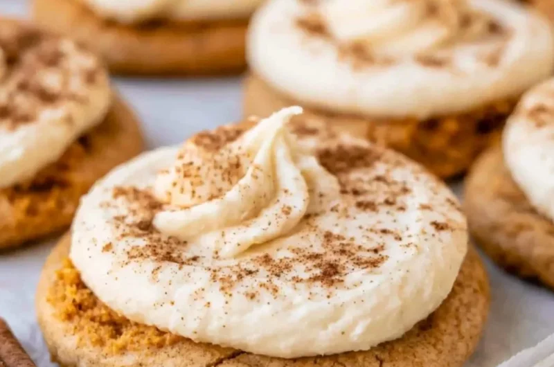 Cozy pumpkin cookies with cream cheese frosting on a autumn-themed plate.