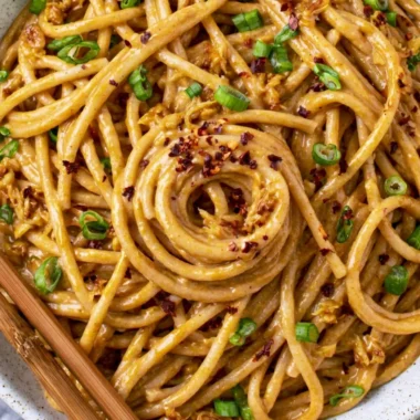 Cozy vegan garlic noodles garnished with fresh herbs and served in a bowl