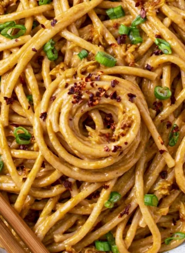 Cozy vegan garlic noodles garnished with fresh herbs and served in a bowl