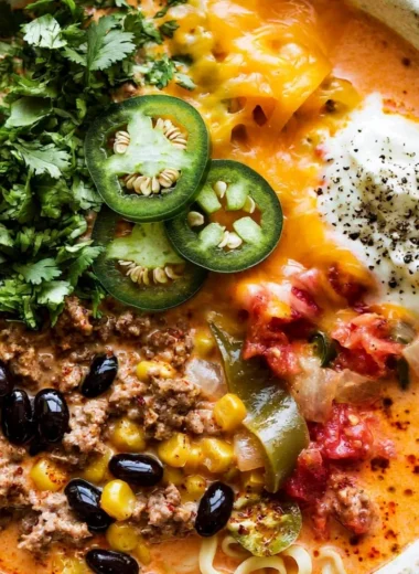 Creamy taco soup garnished with cheese and cilantro in a bowl