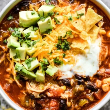 Bowl of Crockpot Chicken Enchilada Soup garnished with cilantro and avocado