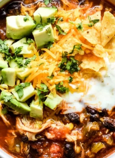 Bowl of Crockpot Chicken Enchilada Soup garnished with cilantro and avocado