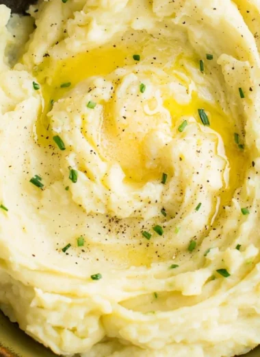 Bowl of perfect creamy mashed potatoes with butter and herbs