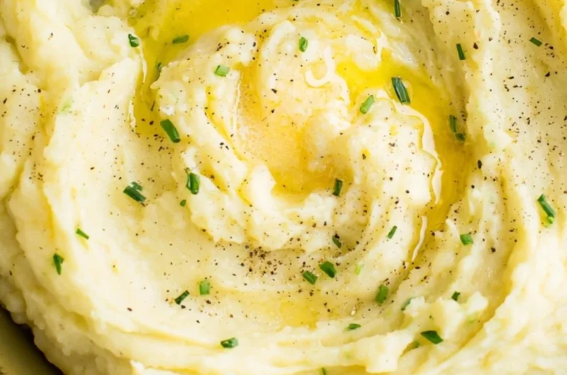 Bowl of perfect creamy mashed potatoes with butter and herbs