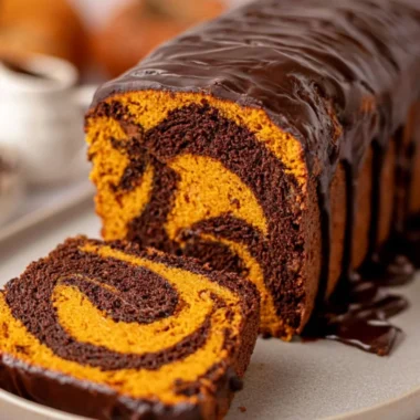 Cozy Vegan Pumpkin Marble Cake topped with walnuts and spices, perfect for fall baking.