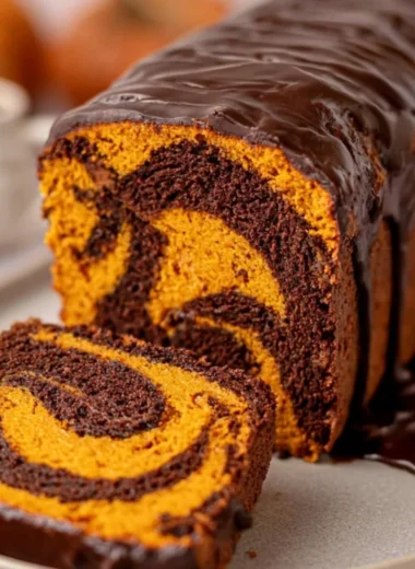 Cozy Vegan Pumpkin Marble Cake topped with walnuts and spices, perfect for fall baking.