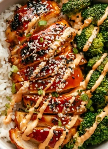 Healthy sticky chicken bowls with colorful vegetables and rice.