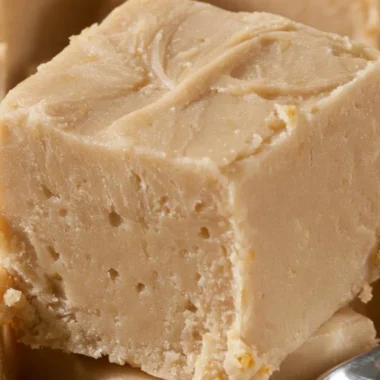 Delicious homemade Peanut Butter Fudge squares on a white plate.
